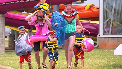 Water-Zoo running family Happy family with props running to Water-Zoo entrance