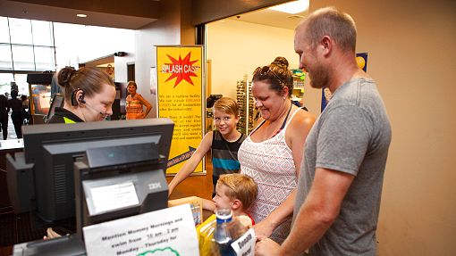Young family purchasing tickets at the front counter at Water-Zoo indoor water park in Clinton, Oklahoma