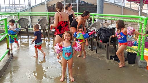 Girl in mermaid suit and moms with children at Water-Zoo Indoor Water Park in Clinton, Oklahoma Girl in mermaid suit and moms with children at Water-Zoo Indoor Water Park in Clinton, Oklahoma